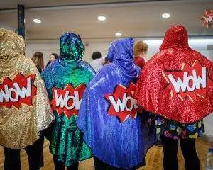 Four sparkly WoW capes being modelled here by four volunteers.